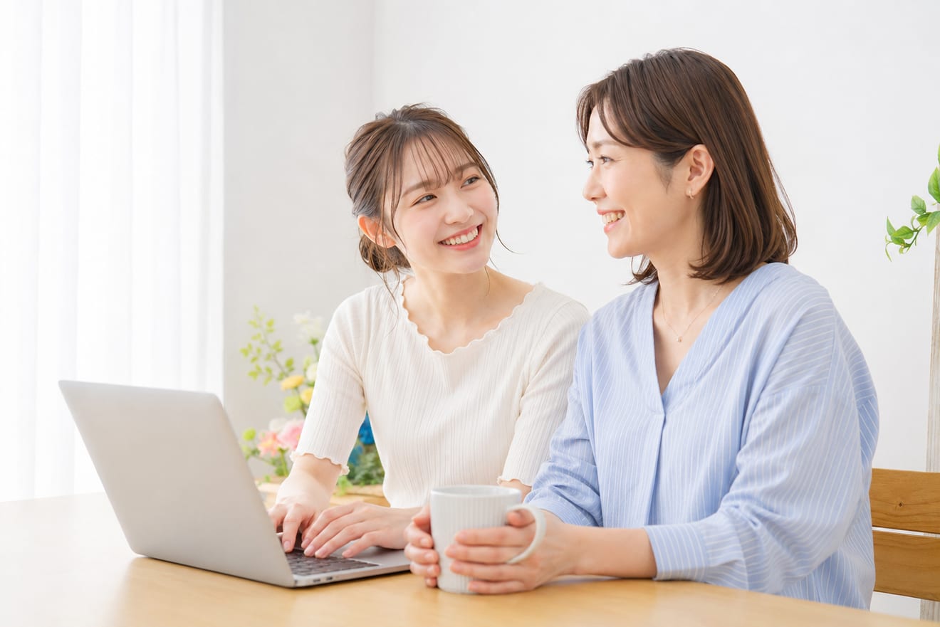 ノートパソコンを前に笑顔で話す親子