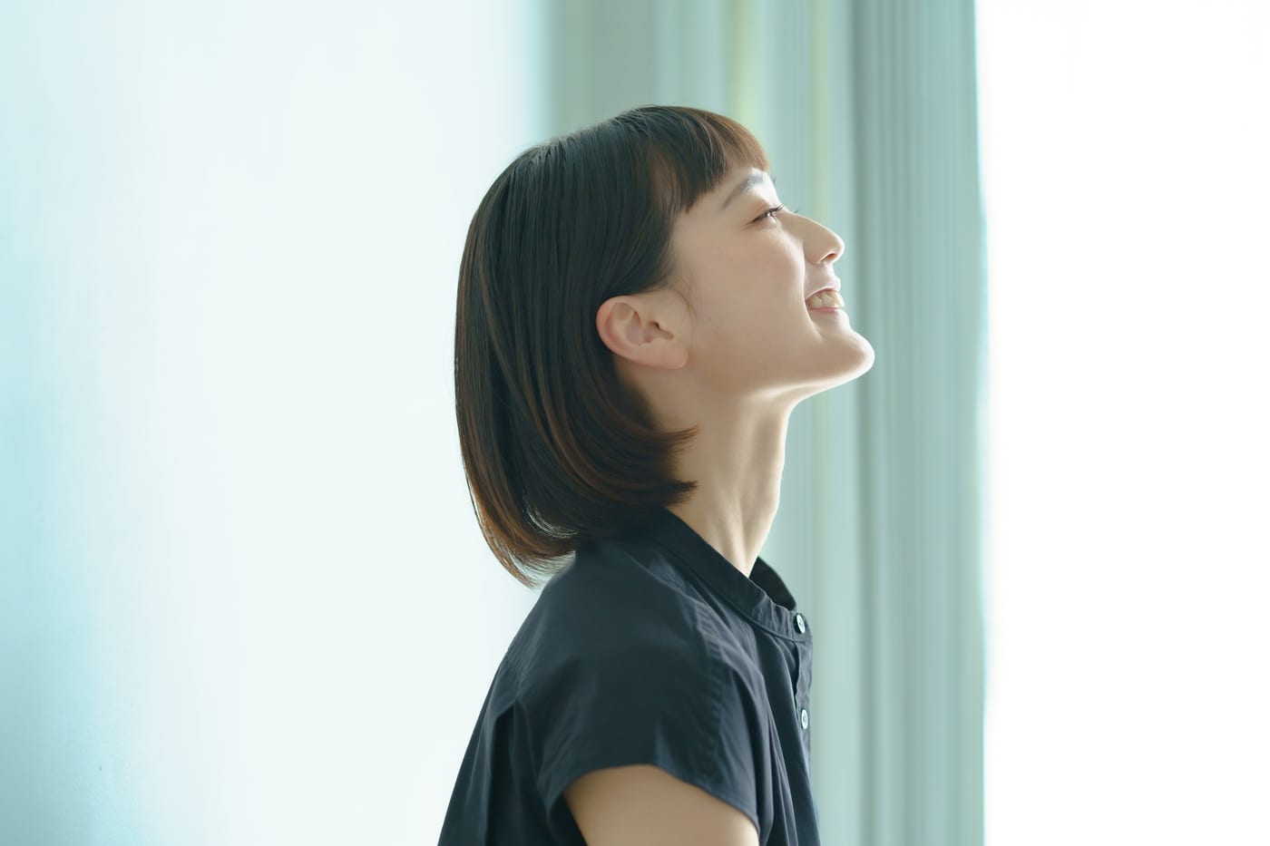 明るい窓辺で前を見上げる学生